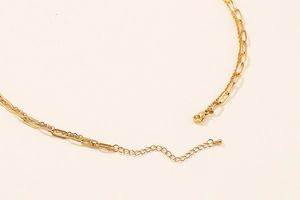 Detail of golden double-layer necklace with lobster clasp and adjustable extension chain