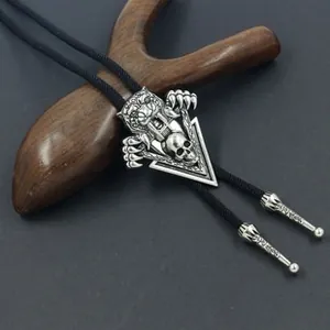 Detail of vintage silver bolo tie with tiger head and skull on leather cord