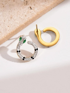 Detailed view of gold-plated snake earrings with sparkling cubic zirconia and green gem eyes