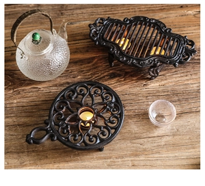 Gros plan du chauffe-thé vintage en fonte avec motif ajouré et texture rustique noire