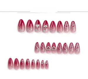 Detail of red gradient almond press-on nails with silver spider and heart 3D charms