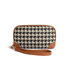 Houndstooth clutch bag for women with brown leather trim and wrist strap on white background