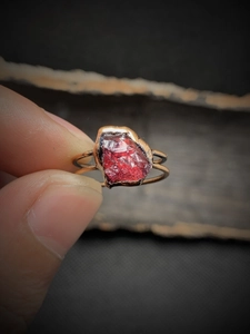 Macro detail of vintage gold adjustable ring with an irregular red natural stone