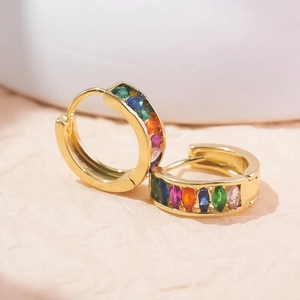 Macro view of gold U-shaped earrings featuring multi-colored marquise gemstones