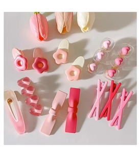 Detailed flat lay of 11 pieces pink flower and bow hair clips with tulip decor