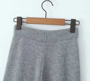 Detailed view of gray ribbed knit trousers featuring a comfortable elastic waistband