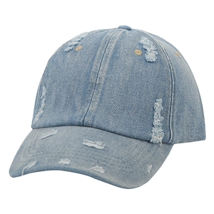 Detail of distressed light blue denim baseball cap with vintage frayed ripped effects