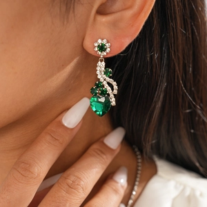 Gros plan de boucles d'oreilles cœur vert en pierre avec des accents de cristaux