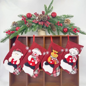Detailed view of four linen Christmas stockings with cartoon Santa and Reindeer designs