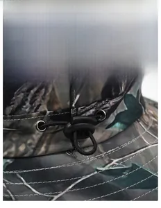 Detailed close-up of adjustable elastic drawstring and metal eyelet on camo outdoor hat