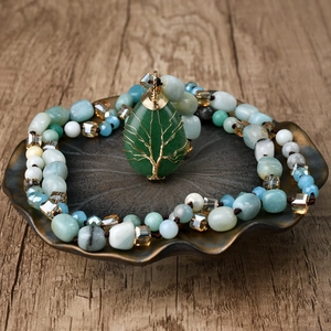 Detail of tree of life wire-wrapped green teardrop stone on a beaded Amazonite necklace