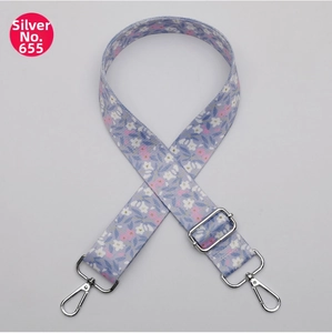 Detail of adjustable floral canvas bag strap with silver metal swivel hooks and buckles