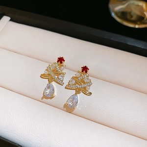 Detailed view of Christmas tree earrings with pearls and crystals in a jewelry box