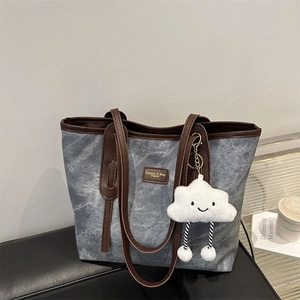 Minimalist denim blue large tote bag with brown leather trim and cloud pendant