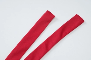 Detail der roten Strickbänder mit feiner Stofftextur und sicher vernähten Enden oben