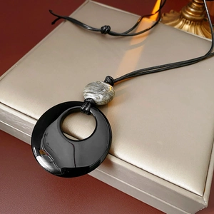 Dettaglio della collana con pendente in agata nera su un cofanetto in raso pregiato