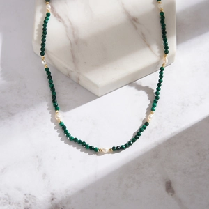 Detail of natural malachite and freshwater pearl necklace with gold-toned spacers