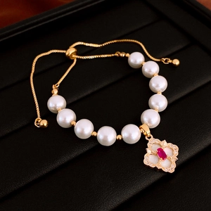 Detail view of gold-plated pearl bracelet with red zircon and adjustable slider clasp