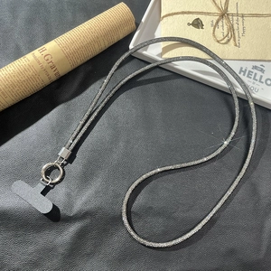 Cordon de téléphone luxe en strass argenté avec clip sur fond de cuir noir élégant