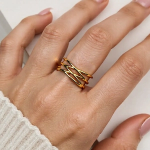 Macro shot of gold-plated multi-layer crossover open ring with hammered texture