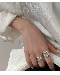 Detail of 925 sterling silver ring with square diamond and bracelet on model