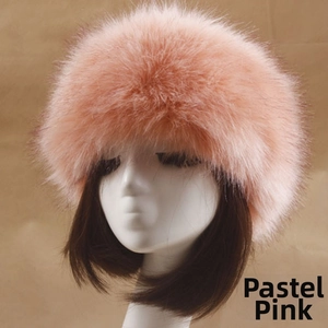Détail de la texture d'un bonnet en fausse fourrure rose montrant des fibres pelucheuses