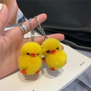 Close-up of soft yellow mink fur duck charms with metallic keychain for bag decor