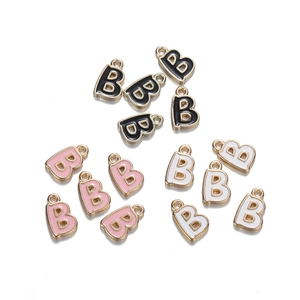 Detail of alloy alphabet letter B charms in black, pink, and white with golden edges
