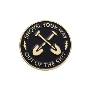 Black enamel shovel badge with golden crossed shovels and engraved quote on the rim
