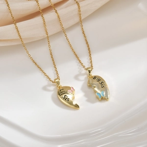 Detail of 18k gold heart puzzle necklaces with Big Sis and Lil Sis engravings