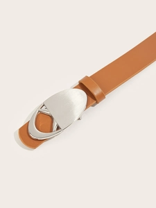 Detail shot of brown leather belt featuring a polished silver heart-shaped metal buckle