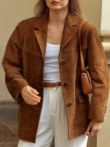 Détail de la texture de la veste en daim marron avec revers classiques et boutons