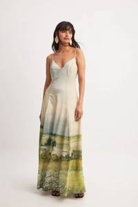 Detail of elegant satin maxi dress featuring pastoral landscape print and slim-fit V-neckline