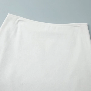 Detail shot of the white skirt's waist featuring premium twill texture and clean stitching