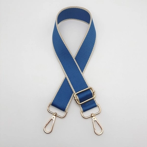 Detail of adjustable blue and beige 3.8cm replacement shoulder strap with gold hardware