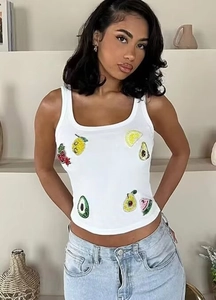 Detail of sequined fruit patches including lemon and cherry on white crop tank top