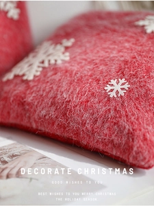 Macro view of Christmas red faux fur pillow with white snowflake appliqué detail