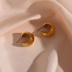 Détail de grosses boucles d'oreilles créoles C plaquées or 18 carats sur soie