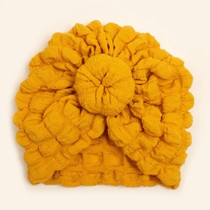 Yellow donut turban hat for babies with soft textured bubble fabric on white background