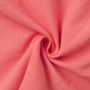 Close-up of coral pink cotton-linen fabric texture showing soft weave and draping