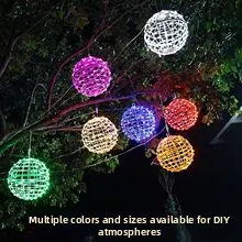 Dettaglio di sfere LED multicolore con rete traforata per decorazione di alberi in giardino