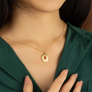 Vintage gold hammer-textured necklace with a red tiger eye stone pendant on a female model