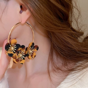 Close-up of leopard print fabric flower hoop earrings worn on a model for a vintage look