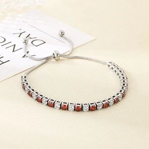 Detail of adjustable silver bracelet featuring red and white zircon stones and slide clasp