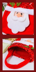 Detail of sequined Santa Claus face and sturdy handles on the red Christmas gift bag