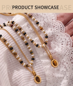 Close-up of double-layered beaded necklace with tiger eye stone and gold oval pendants