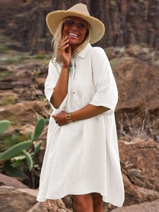 Close-up of white loose cotton linen shirt dress with polo collar and button details