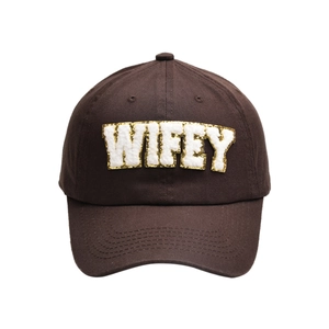 Detail of dark brown cotton baseball cap with WIFEY plush embroidery and gold glitter trim