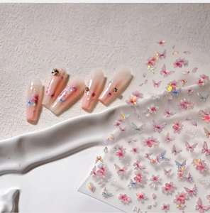 Macro detail of laser butterfly nail stickers with 3D pink floral designs and iridescent finish