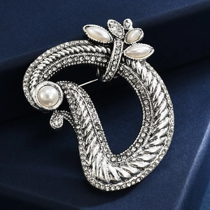 Elegant silver letter D brooch with white pearls and sparkling crystals on blue fabric